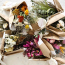 Natural dried flower bouquets in assorted bright colors wrapped in brown paper for wholesale bulk delivery.