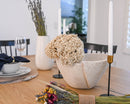 Natural dried starflower bouquet with white blossoms arranged in bulk on wood table.