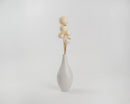 Bleached white dried bell cups arranged in natural stems inside a simple white ceramic vase.