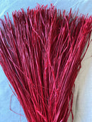 Bulk dried natural raffia bundles in deep red color, perfect for wholesale floral supplies.
