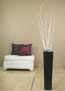 Tall black vase with bleached dried corkscrew willow branches in a bulk wholesale display.