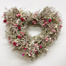A 20-inch wide decorative wreath made of dried flowers in shades of pink and white, with a beige and brown base.
