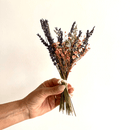 Hand holding natural dried lavender and brown accent flower bouquet for wholesale bulk arrangements.