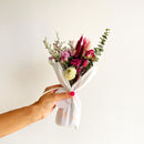 Small pink and natural dried flower bouquet wrapped in white paper, bulk wholesale style.