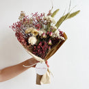 Bouquet of dried flowers with a 'house of lilac' tag on a light background