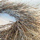 Close-up of a natural brown wreath made of thin branches, showcasing its texture and form.