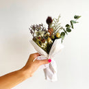 Neutral large dried flower bundle with natural white, nude, and green foliage wrapped in white paper for wholesale bulk.