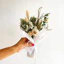 Hand holding a bouquet of flowers with a white background