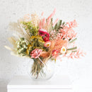 Medium dried flower arrangement in clear vase with pink, yellow, and natural tones, wholesale bulk bouquet.