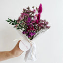 Bouquet of purple flowers with a 'House of Lilac' tag on a white background