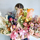 Natural dried flower bouquet wrap in pastel shades with pink ribbons, wholesale bulk arrangement.