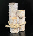 A set of three white birch wood holders of different heights, tied together with a string, against a black background.