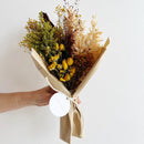 Orange yellow dried petit flower bouquet wrap with natural greenery in bulk wholesale style.