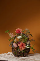 Natural dried floral arrangement in rustic vine basket with wholesale bulk appeal.