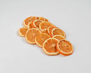 Stack of dried natural orange slices arranged on a white background, showcasing bulk wholesale fruit product.