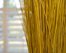 Bundle of natural dried meadow grass in a bulk wholesale case with golden stems.