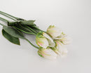 A bundle of artificial tulip stems with cream green petals and leaves on a white background.