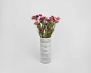 Pink dried strawflowers arranged in a white striped vase, natural bulk bouquet.