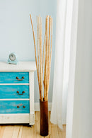 Tall natural dried river cane branches in a brown vase, shown in bulk wholesale bundle.