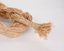 Natural tan raffia hank with tightly bundled dried fibers, bulk and wholesale supply.