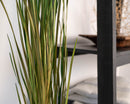 Bulk natural dried ornamental wild grass with slender green and beige blades in a modern interior setting.
