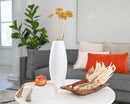 Dried yellow yarrow bunches arranged in a white vase on a white table in a modern living room setting.