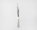 Tall white ceramic vase holding natural dried brown birch branches in a minimalist setting.