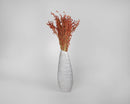 Bulk dried red broom corn bunches arranged in a tall white ceramic vase, natural decorative plant.