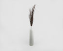 Bundle of dried ornamental wild grass in natural brown color arranged in tall gray ceramic vase.