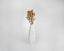 Natural dried sunflowers in yellow and light green stems arranged in tall white textured vase, bulk wholesale display.