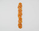 Bulk natural dried orange slices arranged in a vertical line on a white background.