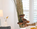 Bundle of dried natural dune grass with brown seed pods in white vase, bulk wholesale arrangement.