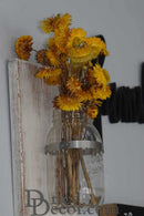 Dried natural yellow strawflowers in a clear glass vase with metal accent, wholesale bulk display.