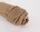 Rolled natural tan jute cloth in bulk, coarse woven texture ideal for dried floral supplies.