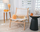 Bulk dried blond wheat sheaves arranged on chair and table in bright room with modern decor.