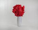 Bundle of vibrant red dried oak leaves arranged in a tall white vase, showcasing natural texture for wholesale bulk use.