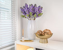 Bundle of 12 dried lilac spray stems with natural lavender blooms in white vase for wholesale bulk purchase.