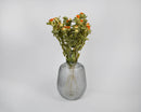 Bulk dried safflower bunches with natural orange flowers and green stems in a clear ribbed glass vase.