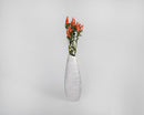 Tall white ceramic vase with a bulk bunch of dried natural Indian Paintbrush flowers in orange to red hues.