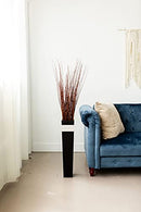 Tall bundle of dried natural Asian willow branches in a sleek black vase for wholesale bulk use.