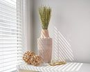 Light green dried fan grass bunches in textured vase, natural bulk decor with soft sunlight shadows.