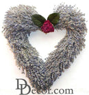 Heart-shaped wreath made of dried natural lavender with green leaves and a small cluster of pink flowers at the top center,.